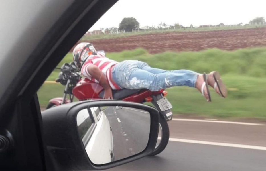 Motociclista pilota moto deitado em alta velocidade na BR-376