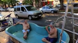 Unindo o útil ao agradável: grupo de amigos monta piscina em frente a bar